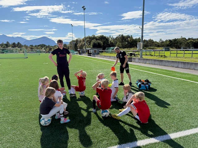 Barn og trenere på fotballbane